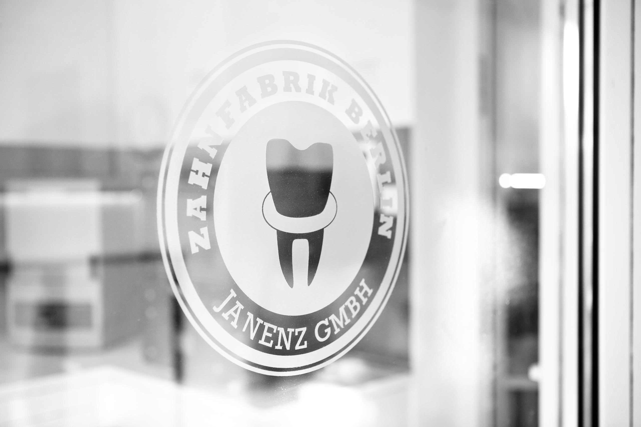 Logo der Zahnfabrik Berlin als Folie auf einer Glastür